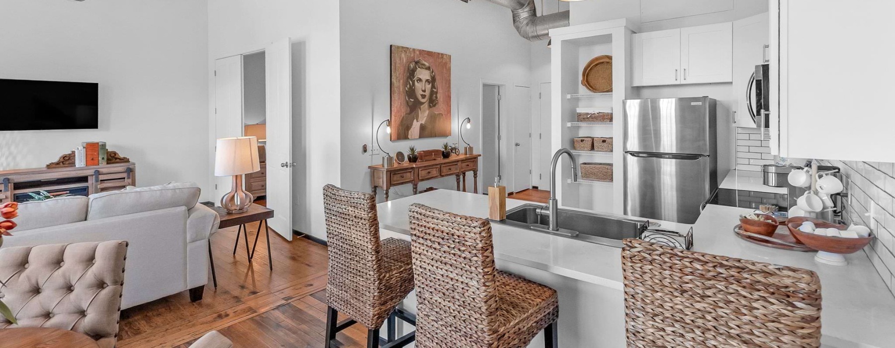 Spacious well lit kitchen with wood floors and stainless steel appliances
