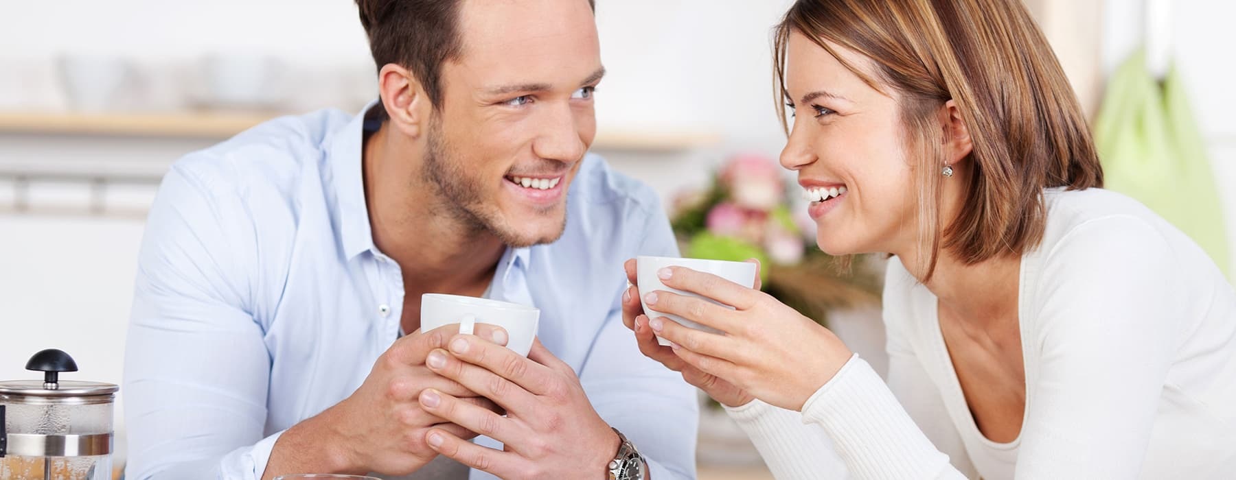 lifestyle image of a couple laughing and talking inside a kitchen